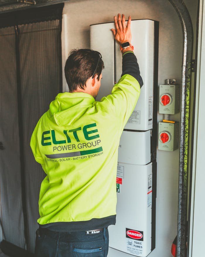 <font dir="auto" style="vertical-align: inherit;"><font dir="auto" style="vertical-align: inherit;">家</font></font> Technician installing a solar inverter and battery system in New South Wales.