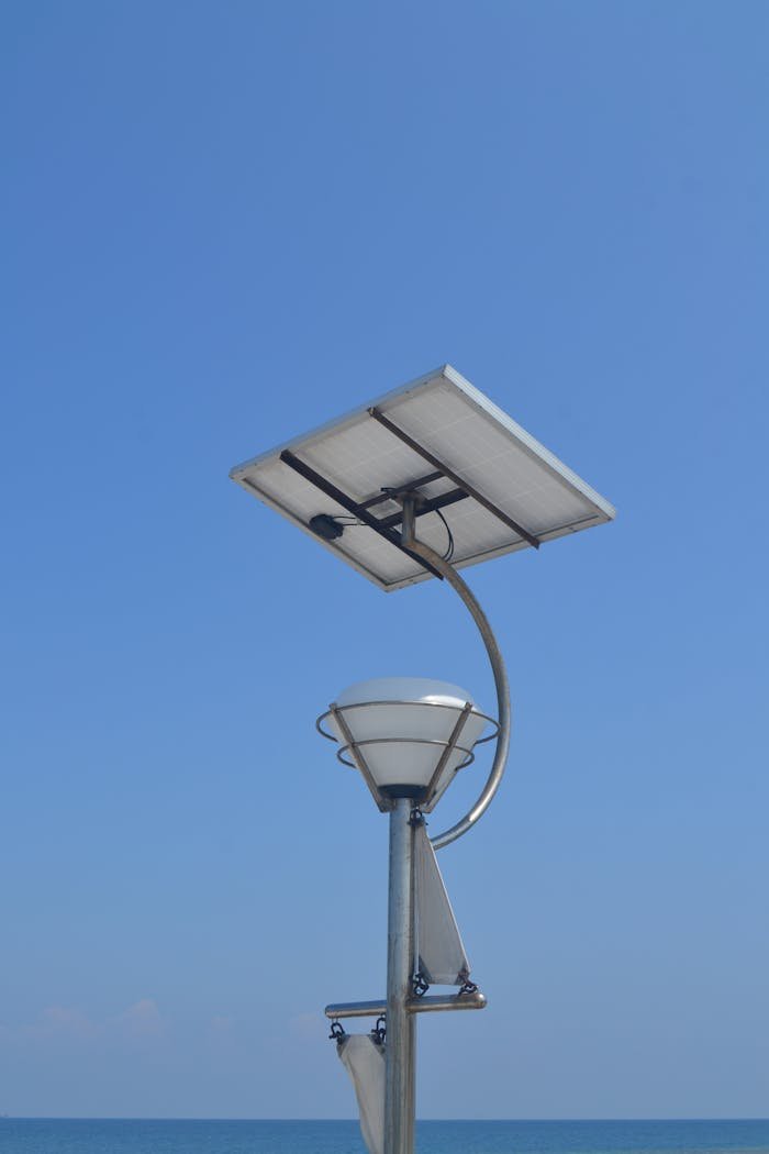 Solar-powered street lamp against a clear blue sky in Jakarta, showcasing renewable energy solutions.